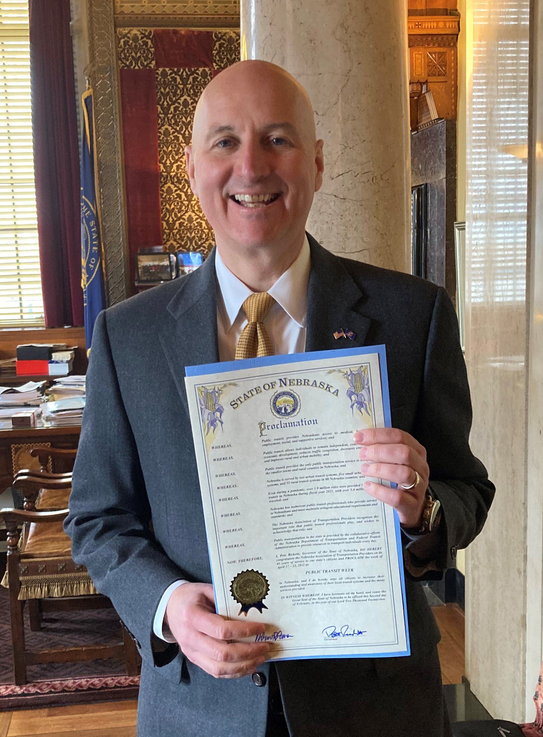 photo of Nebraska Governor Pete Ricketts holding the 2022 Nebraska Public Transit Week proclamation