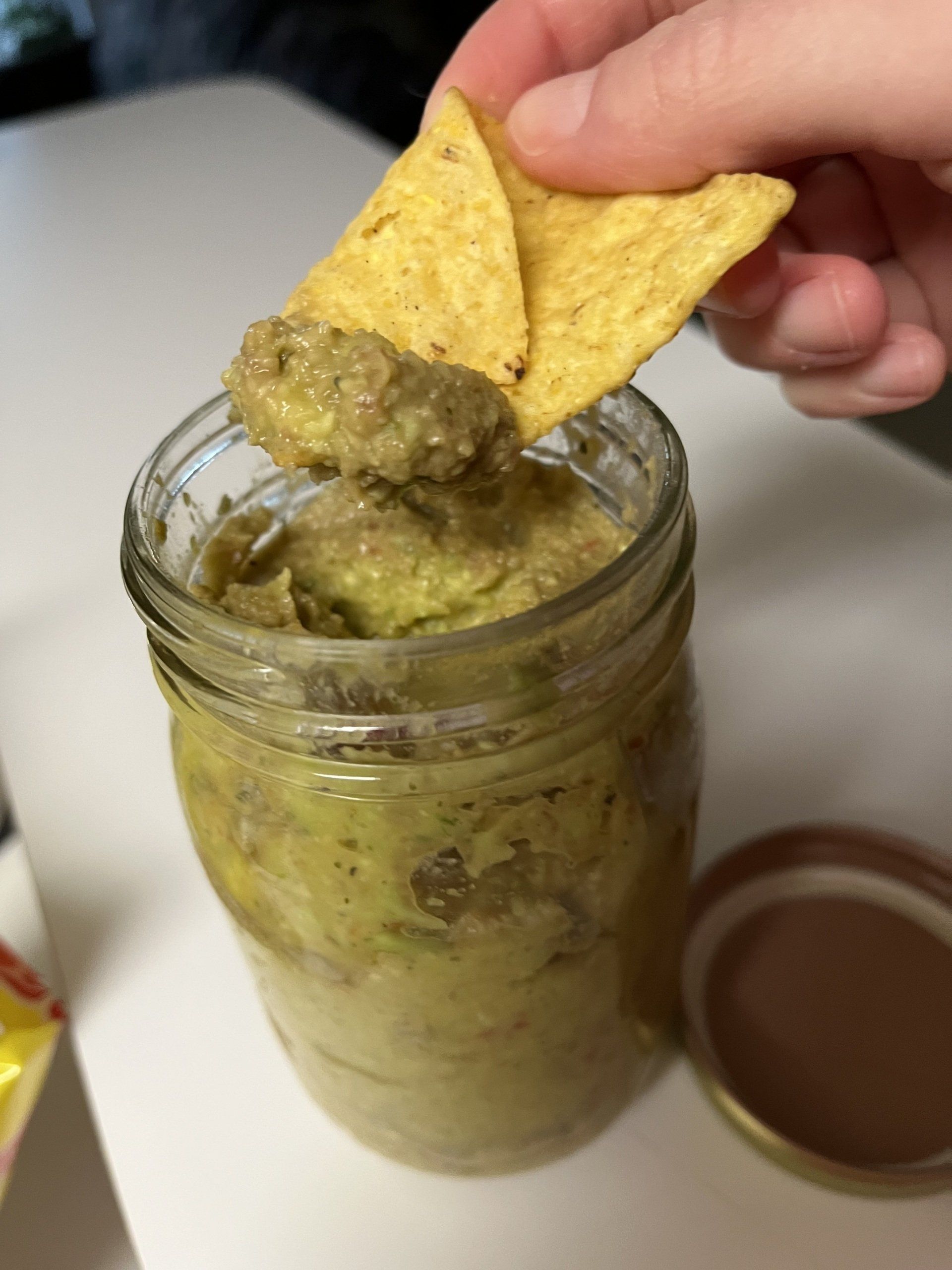 photo of a chip being dipped into guacamole