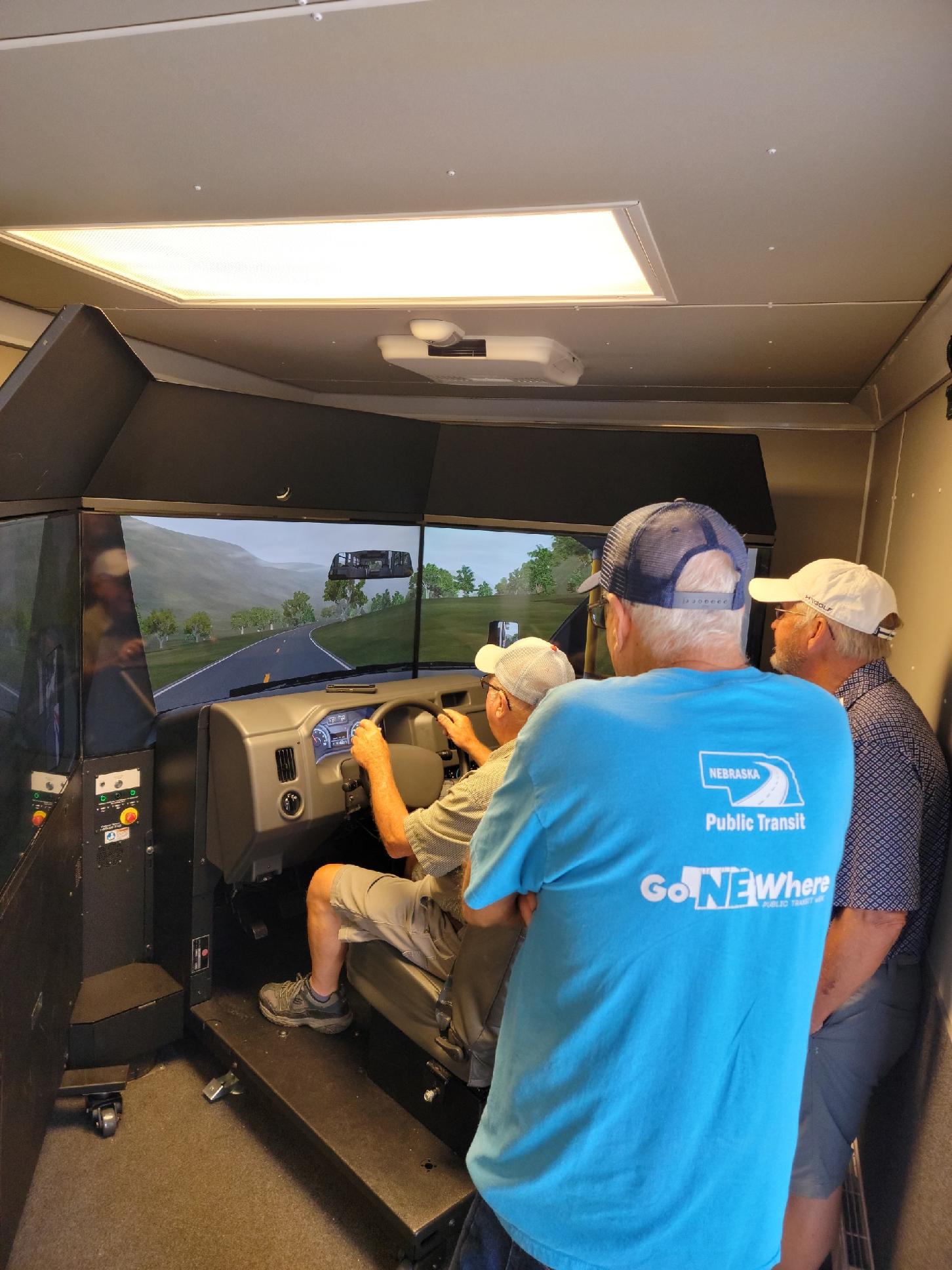 Photo of transit drivers watching another driver participate in the RIDE Simulator