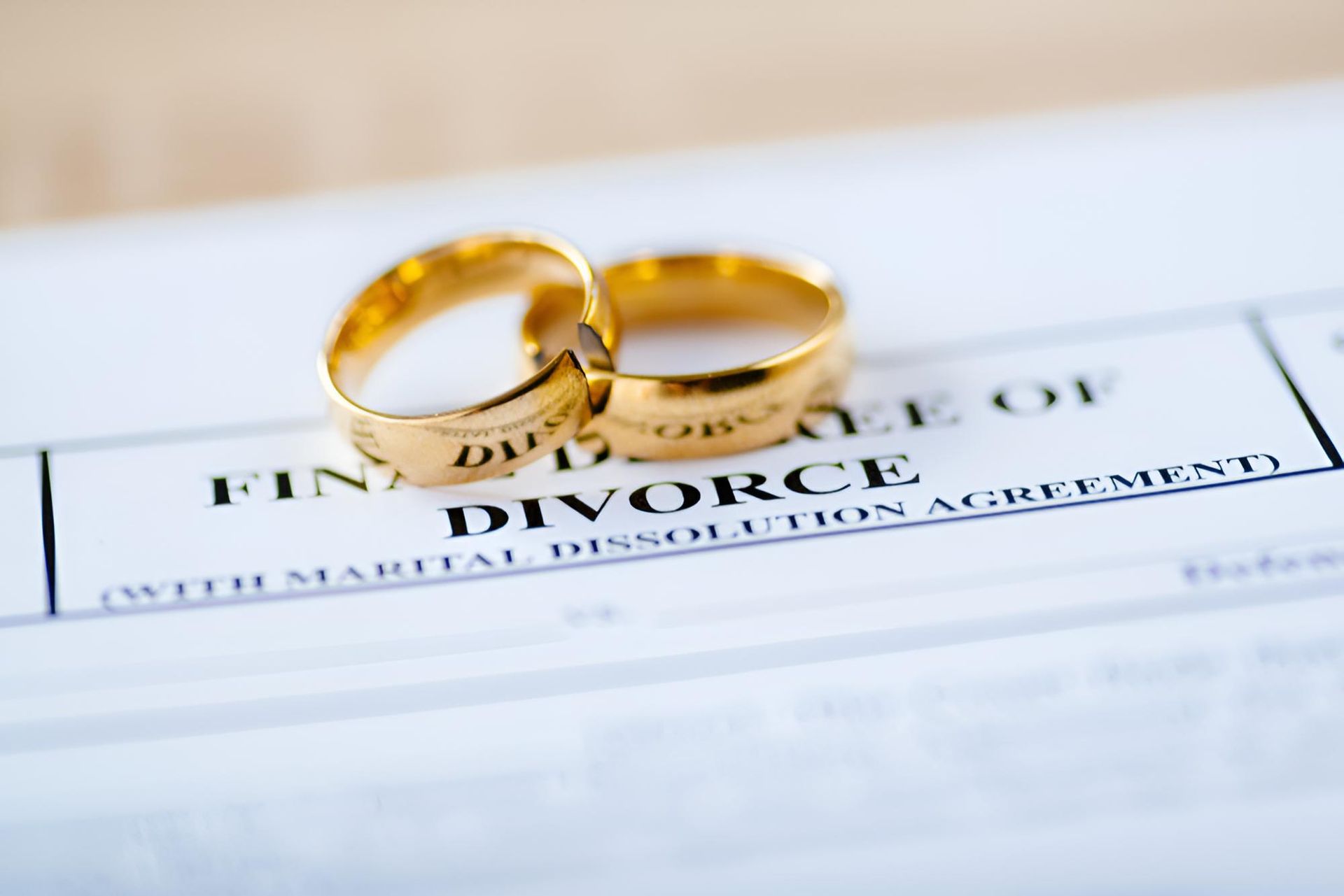 Two Gold Wedding Rings on Top of a Divorce Agreement — Bradley J Bragg - Solicitor in Atherton, QLD