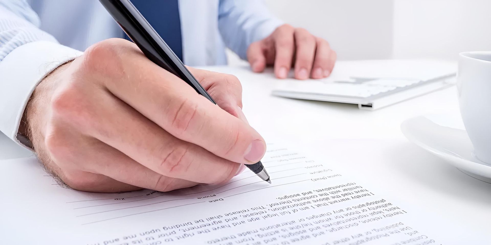 A Man is Writing on a Piece of Paper With a Pen — Bradley J Bragg - Solicitor in Atherton, QLD