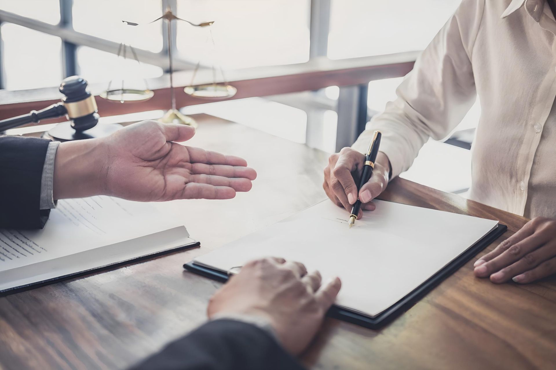 A Man is Giving a Woman a Pen to Sign a Document — Bradley J Bragg - Solicitor in Mareeba, QLD