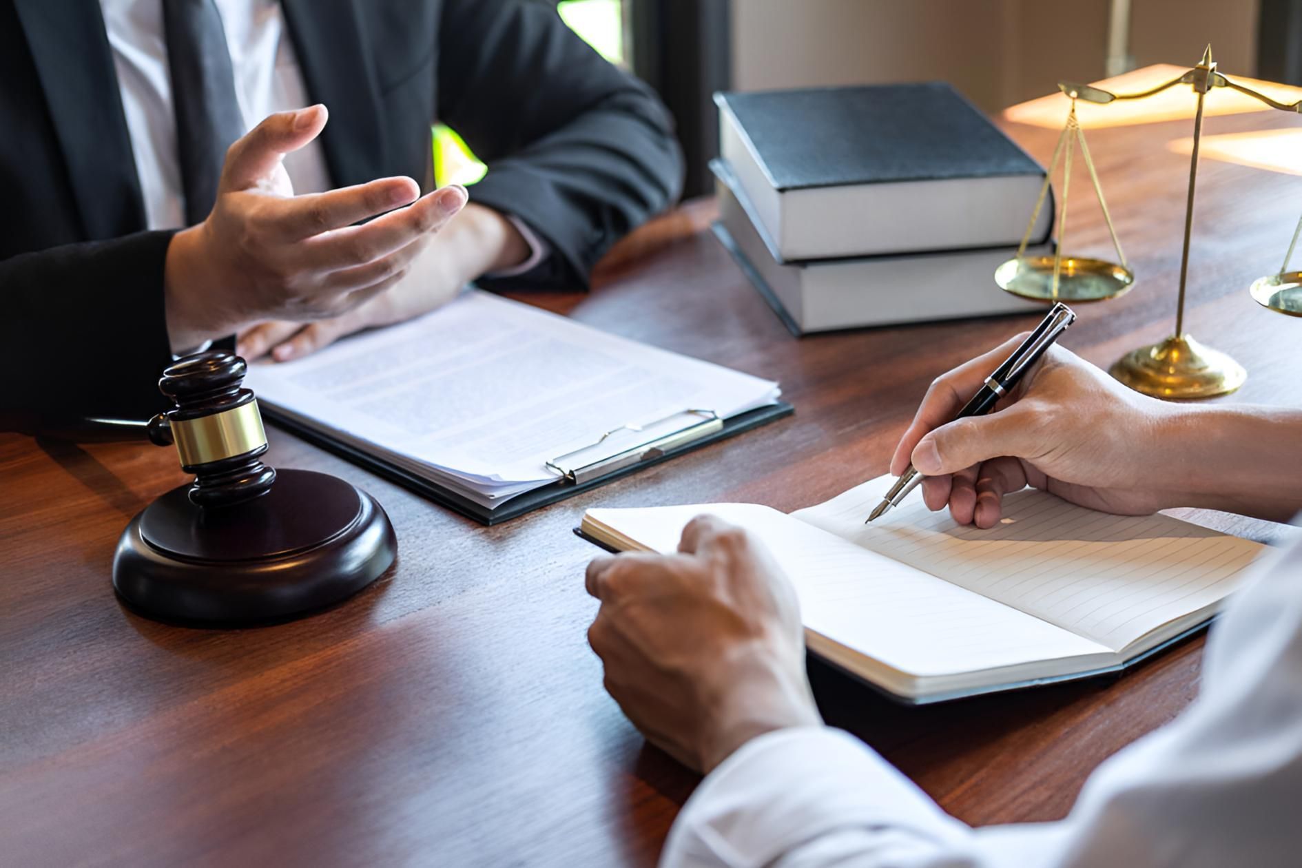 A Man and a Woman at a Table With a Judge's Gavel and Scales of Justice — Bradley J Bragg - Solicitor in Mareeba, QLD