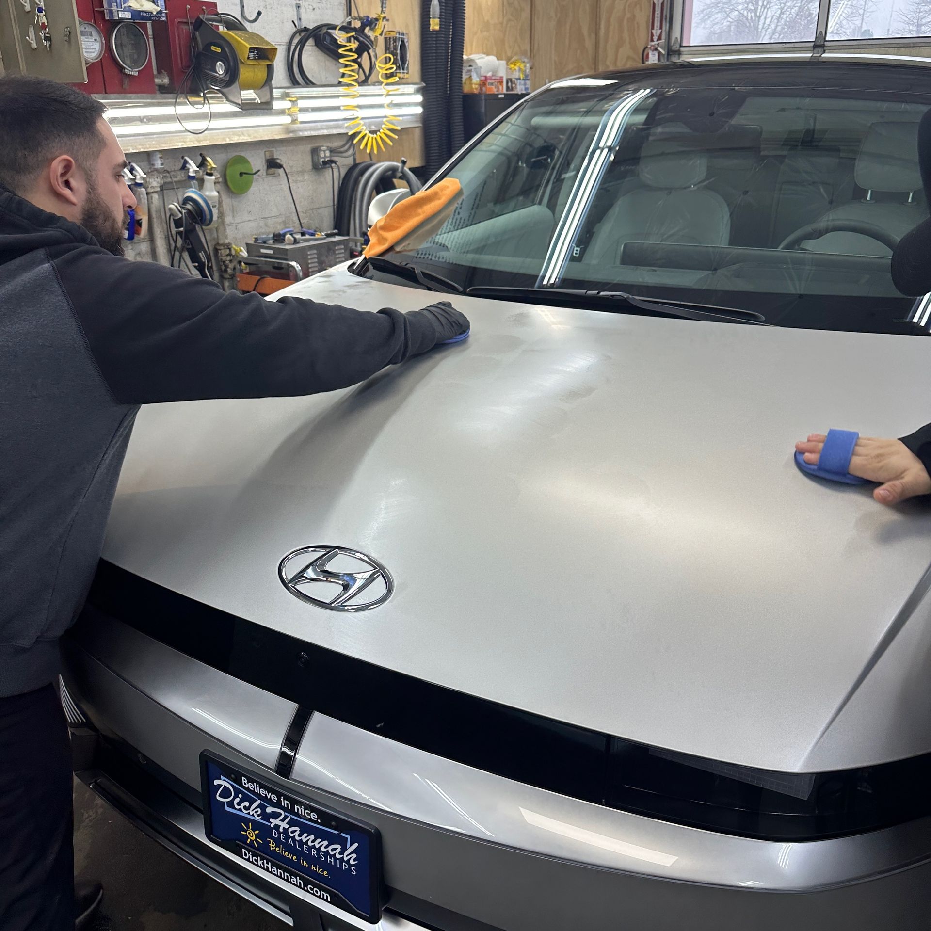 workers apply ceramic coating to matte-painted car