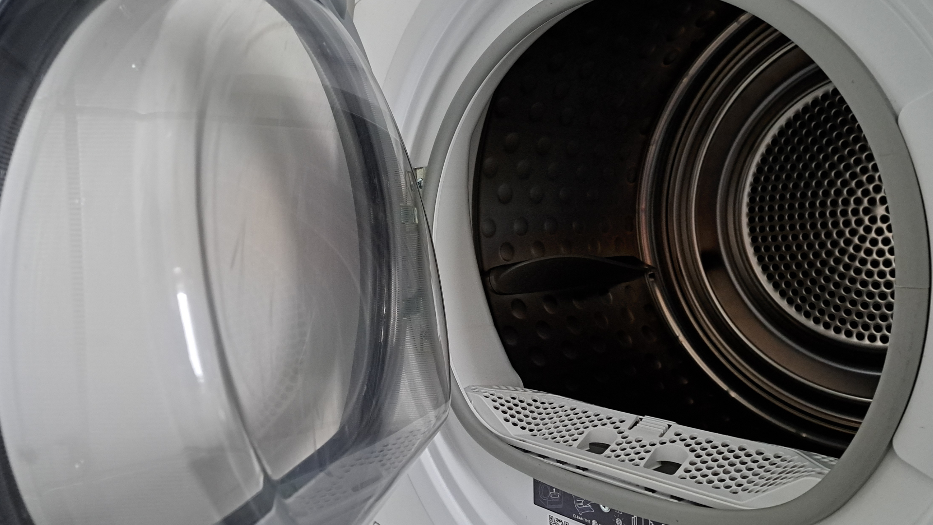 Open dryer door revealing the interior drum with a lint trap visible.