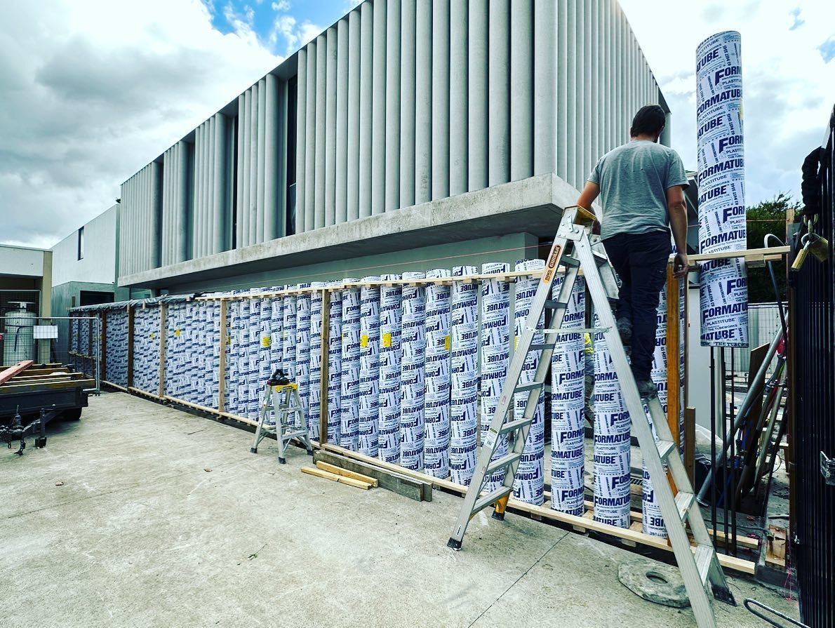 A man is standing on a ladder in front of a building.