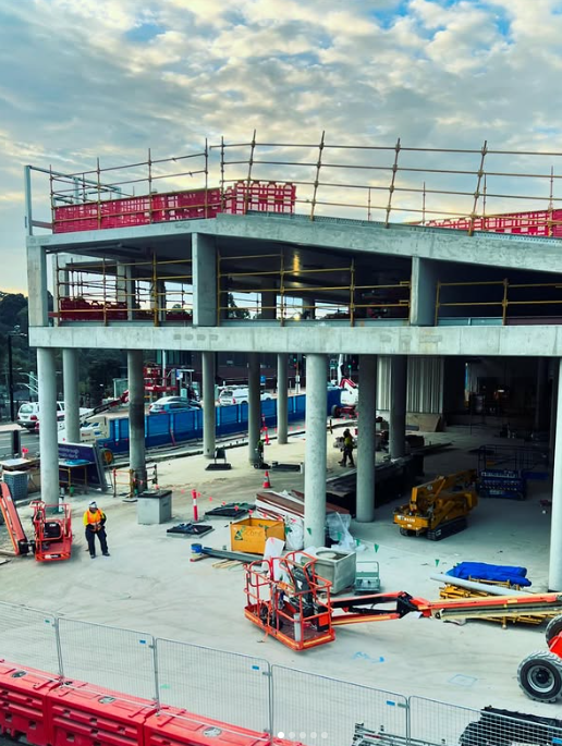 A large building is being built with a lot of construction machinery.