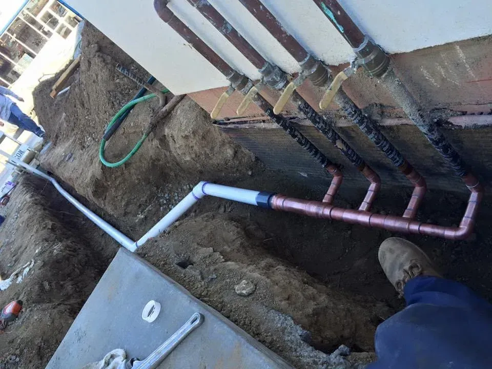 Copper pipes are being installed on the side of a building
