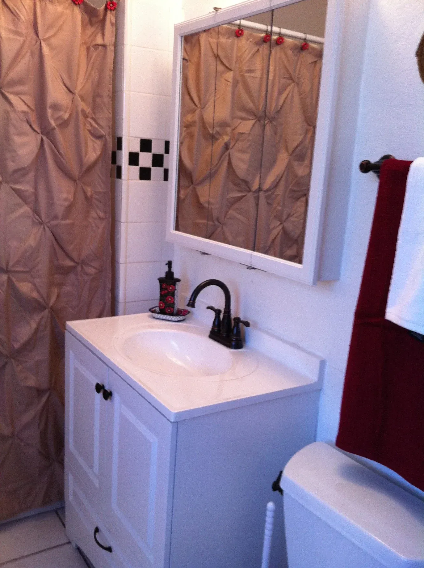 A bathroom with a sink a toilet and a mirror