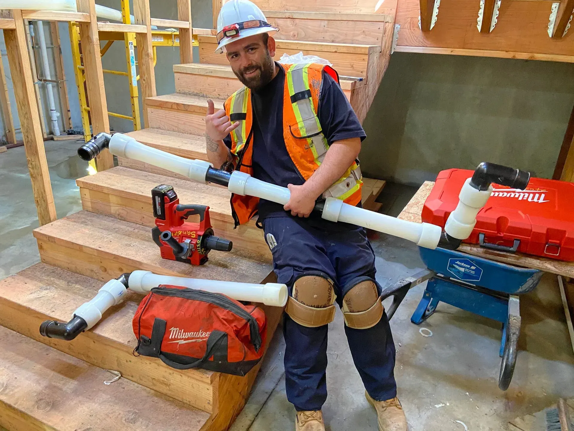 A man is sitting on a set of stairs holding a vacuum cleaner.
