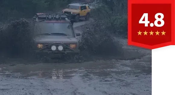 A car is driving through a muddy area with a Reviews rating graphic displayed, 5 stars | The Shop Norcross