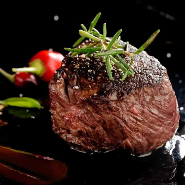 a close up of a steak on a plate with vegetables