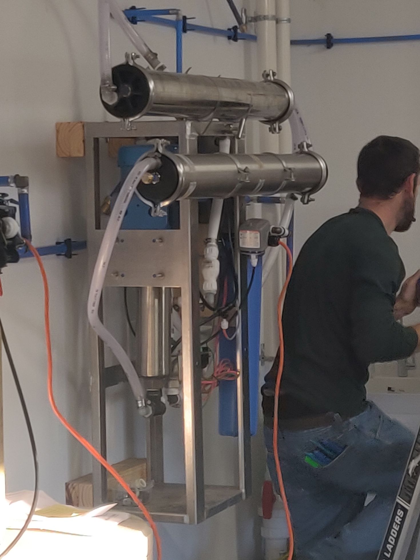 A man is working on a machine with a ladder in his pocket