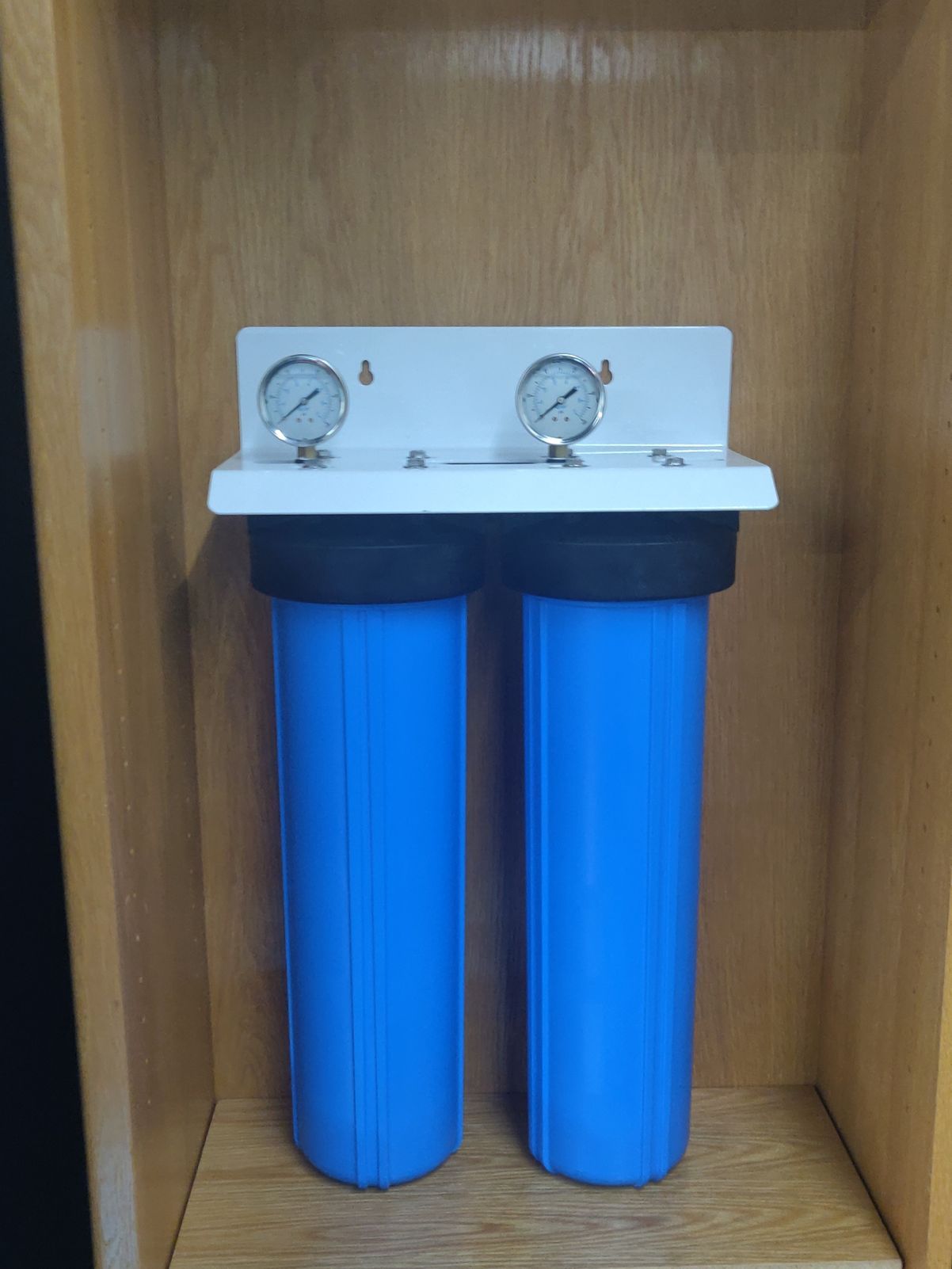 Two blue water filters are sitting on a wooden shelf.