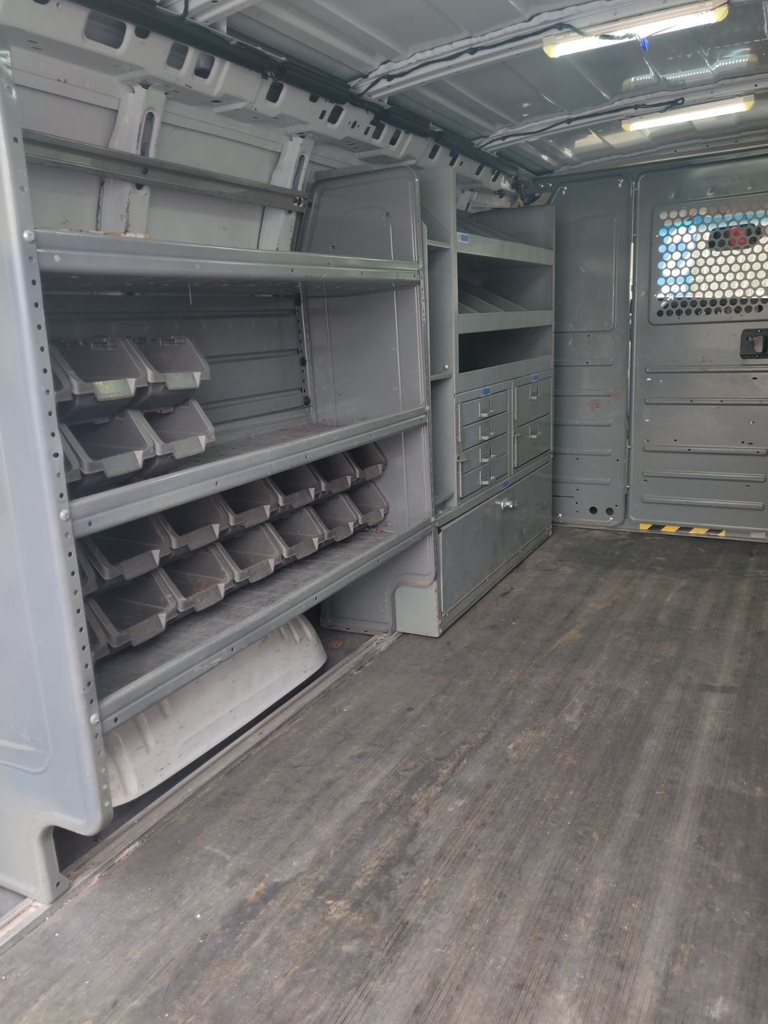 The inside of a van with shelves and drawers.