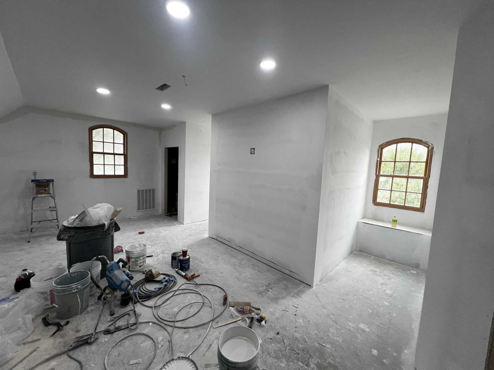 A room with white walls and a lot of tools on the floor.