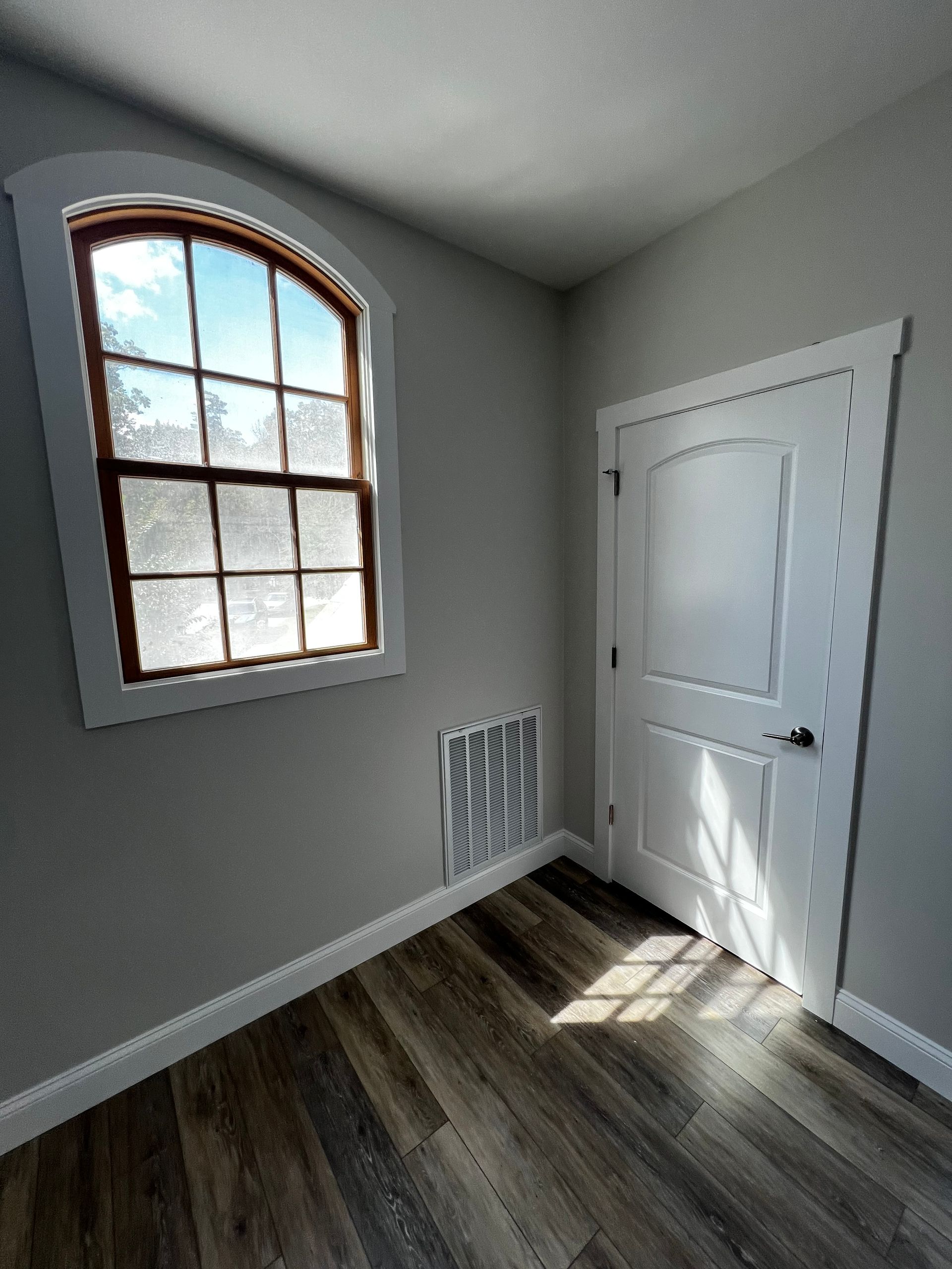 An empty room with a window and a door.