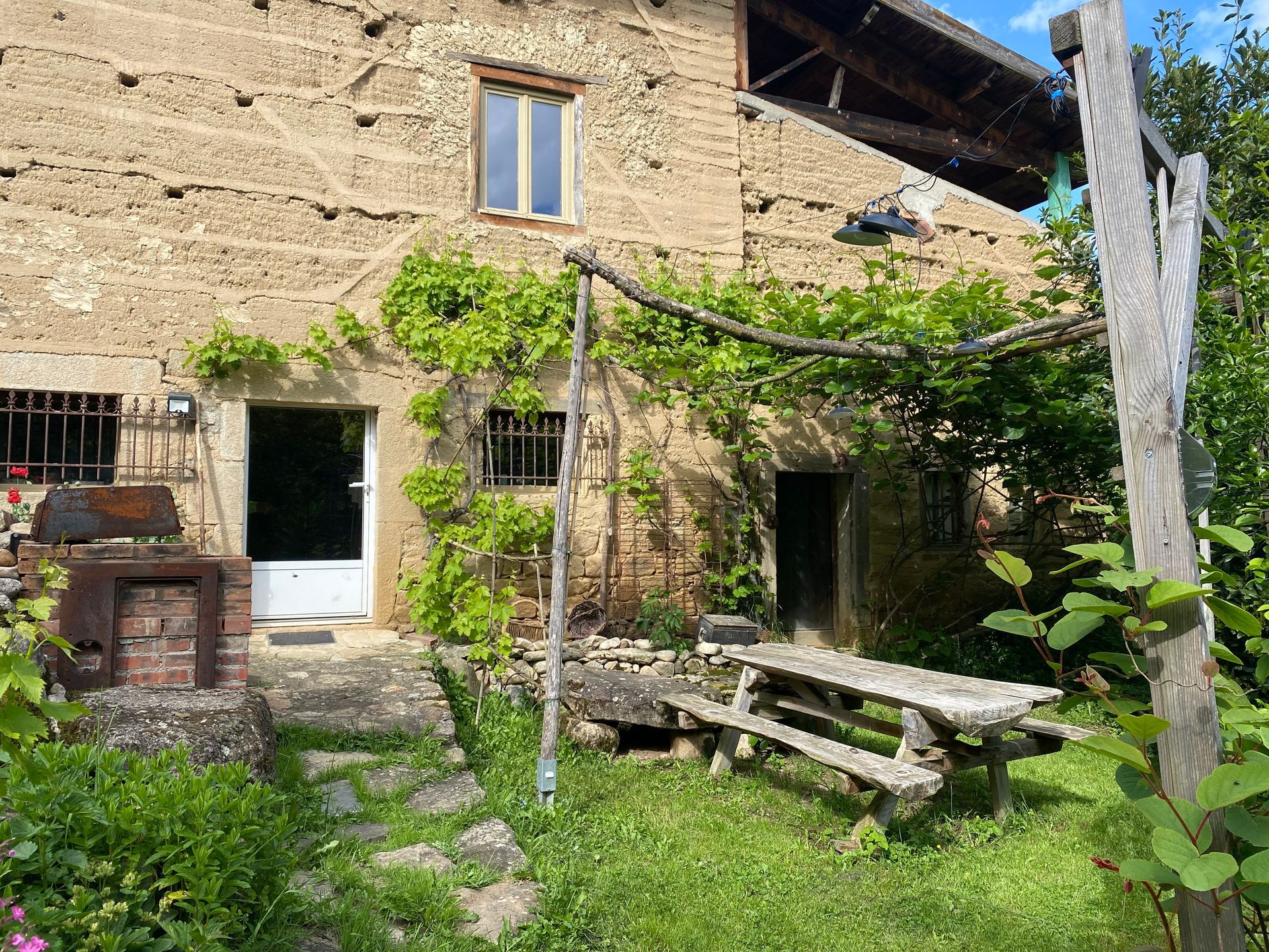 Façade d'une maison avec un jardin arboré.