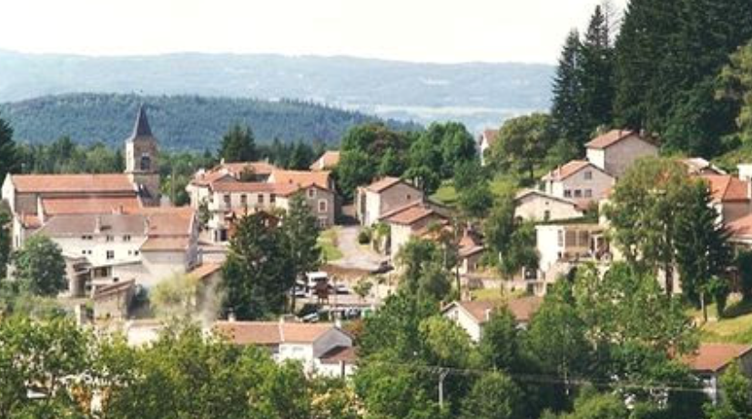 Petit village de montagne entouré de verdure à flanc de montagne.
