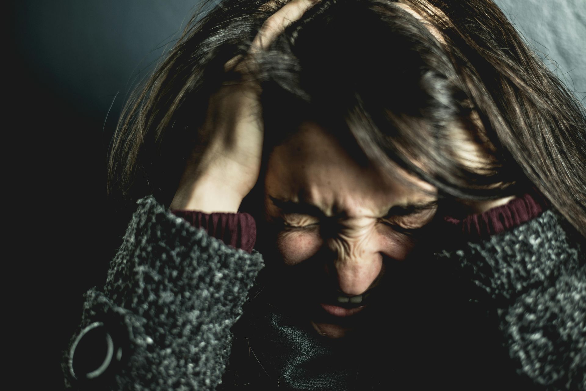 Distressed woman with a pained expression, representing the emotional impact of trauma.