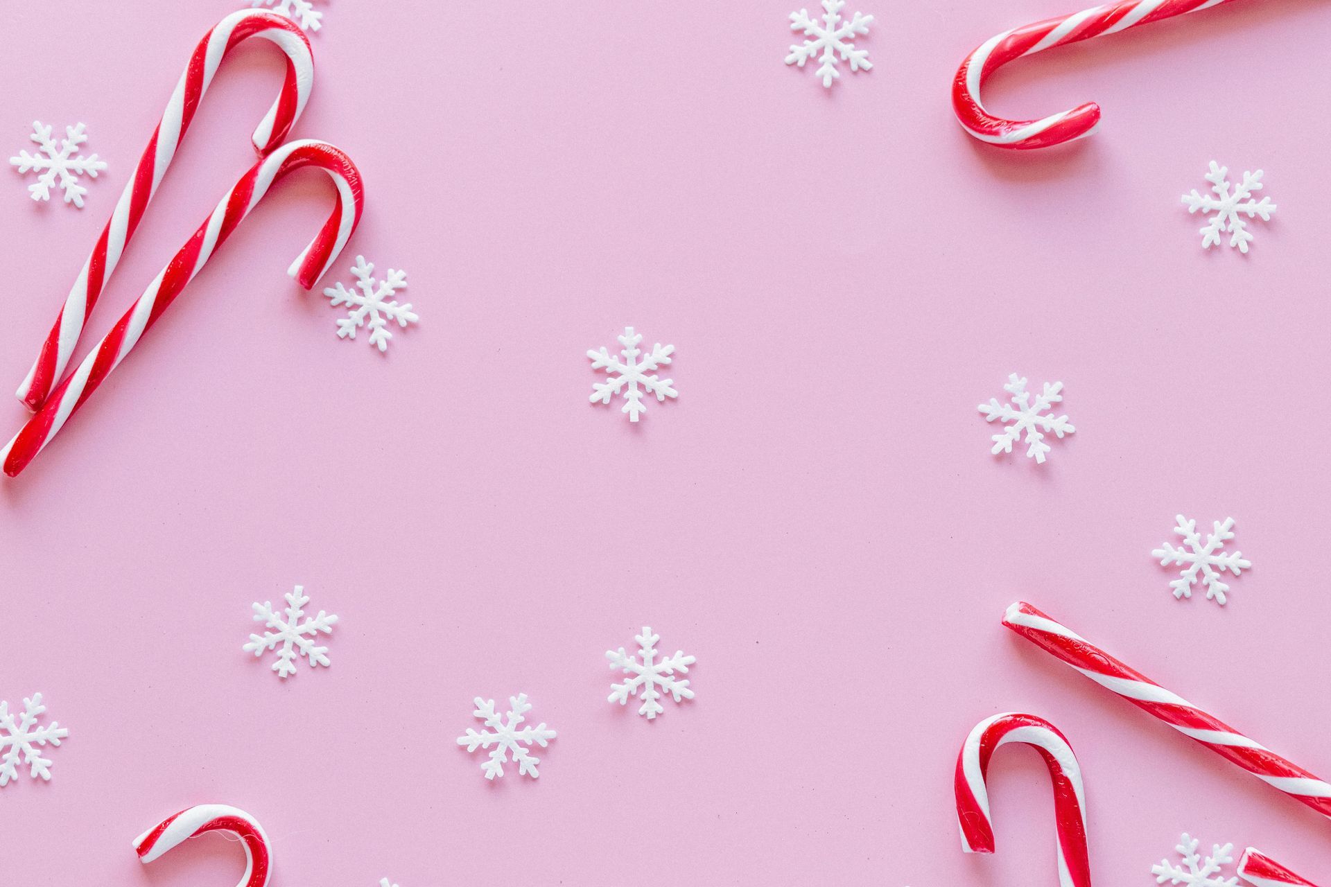 Snow flakes and candies on a pink background