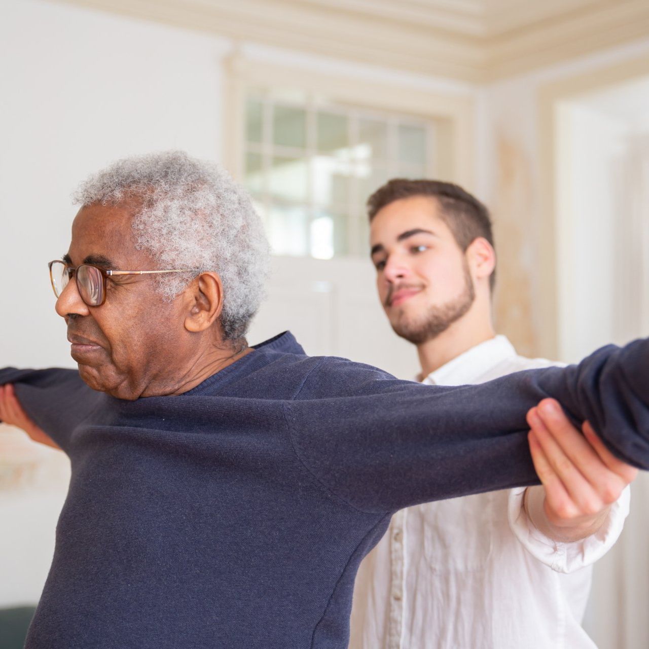 Elderly man receiving support from a male carer