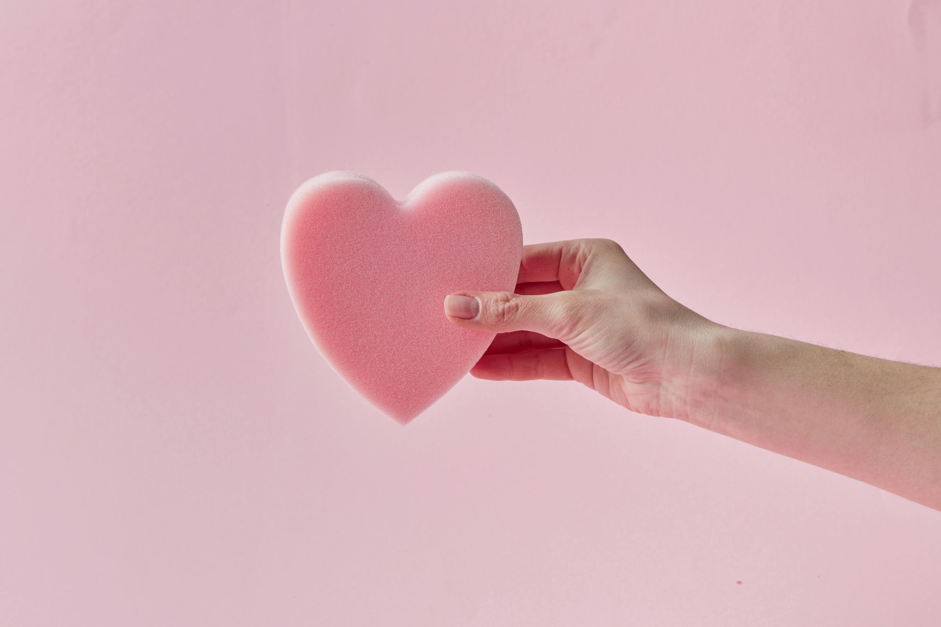A hand holding a cut out love