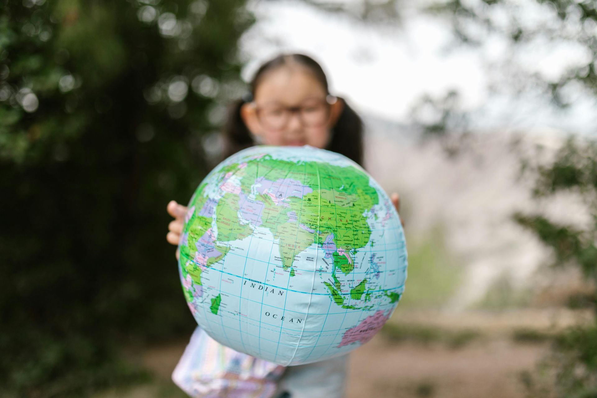 A girl with learning disabilities holding a globe for World health day