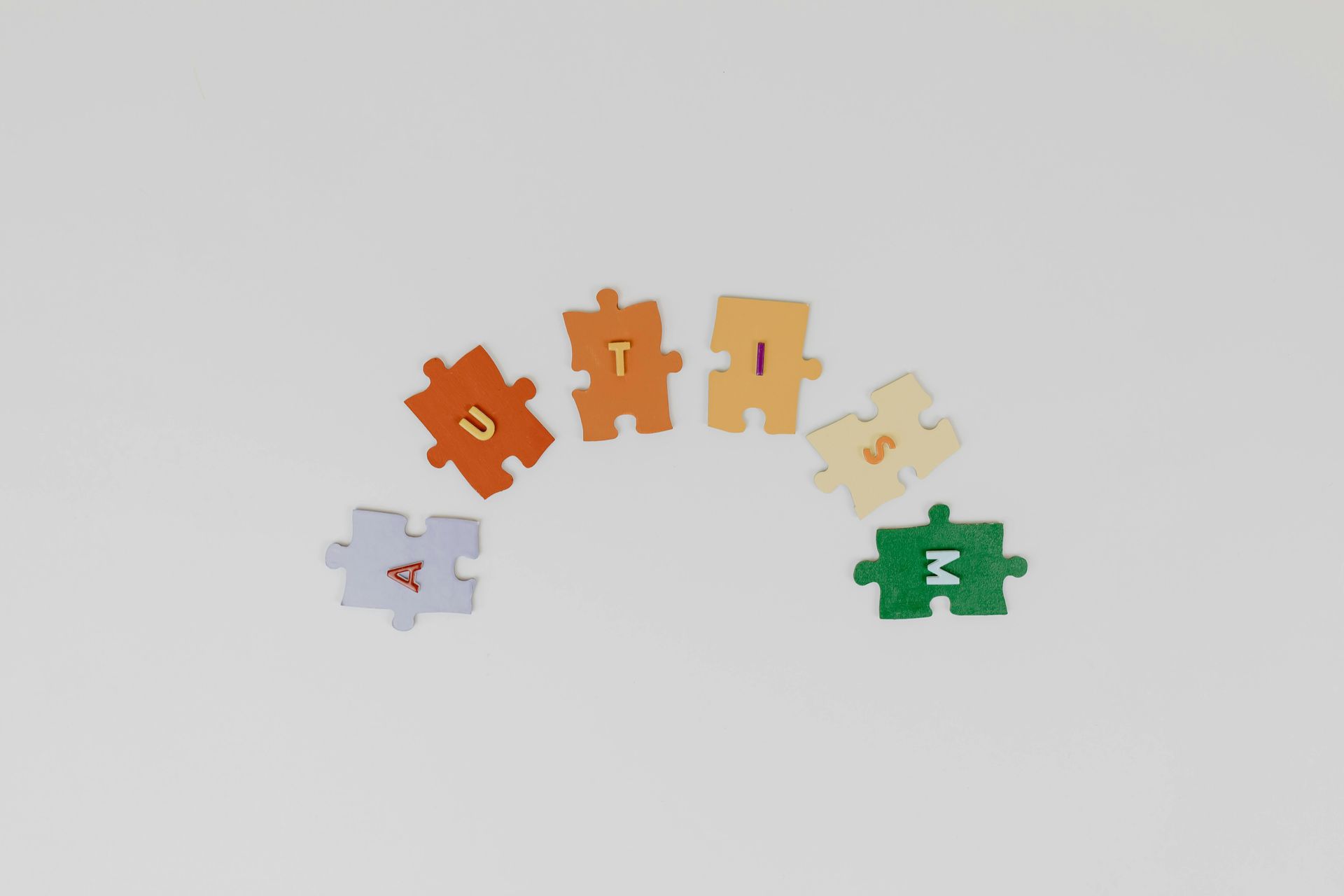 Puzzle pieces spelling AUTISM