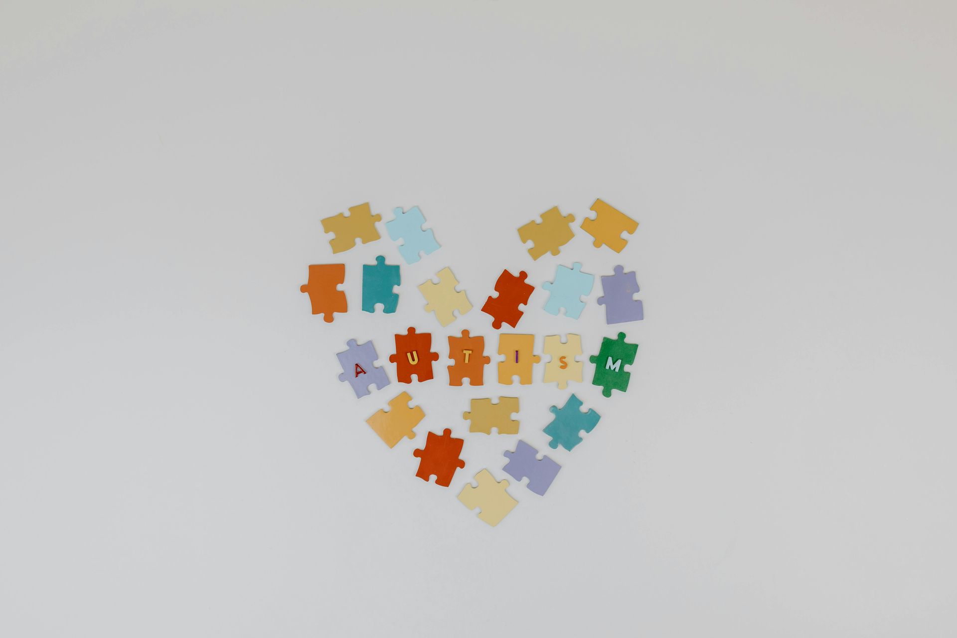 different colored puzzles forming a heart to represent autism