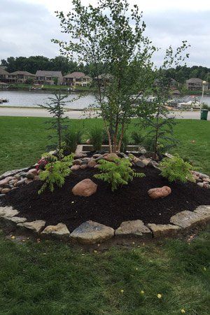 Circle landscaping with rock perimeter and mulch