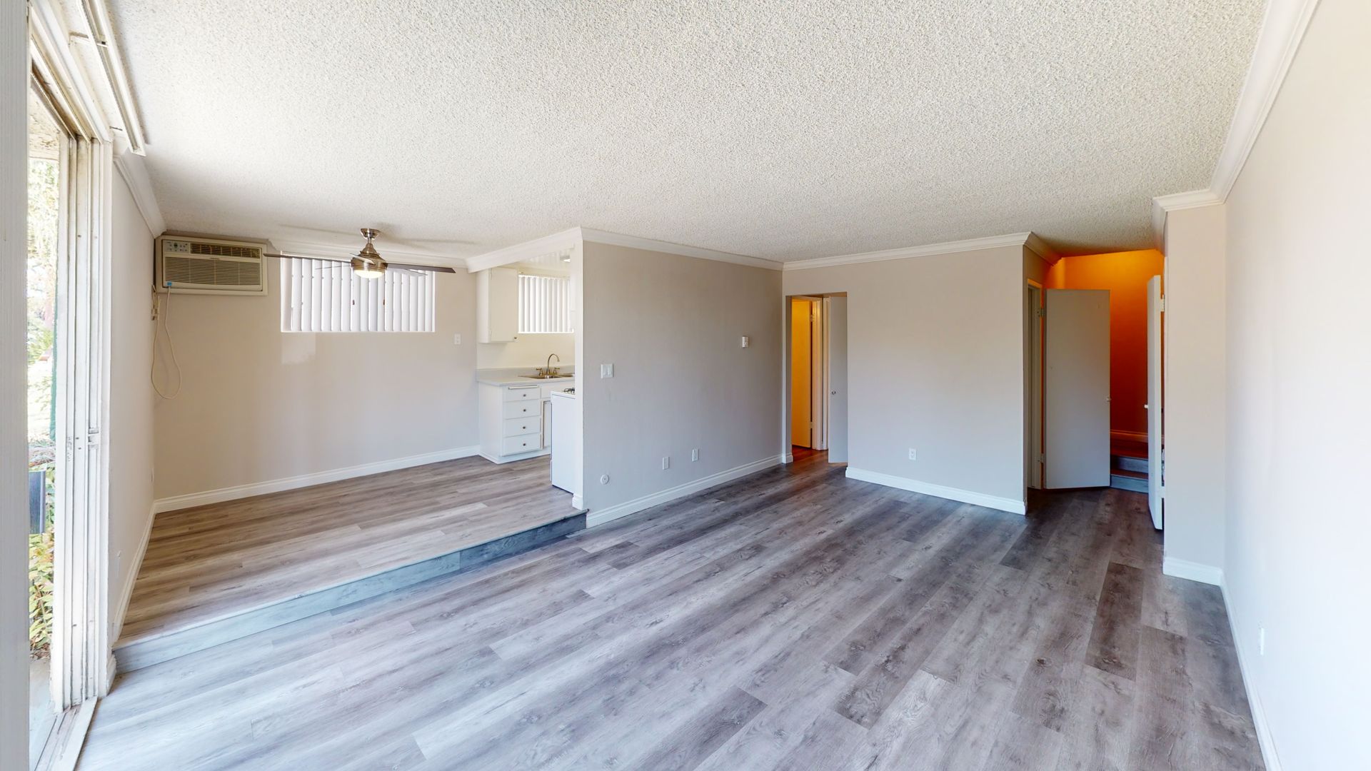 Living room interior with gray wood-look flooring, light gray walls, and white ceiling.