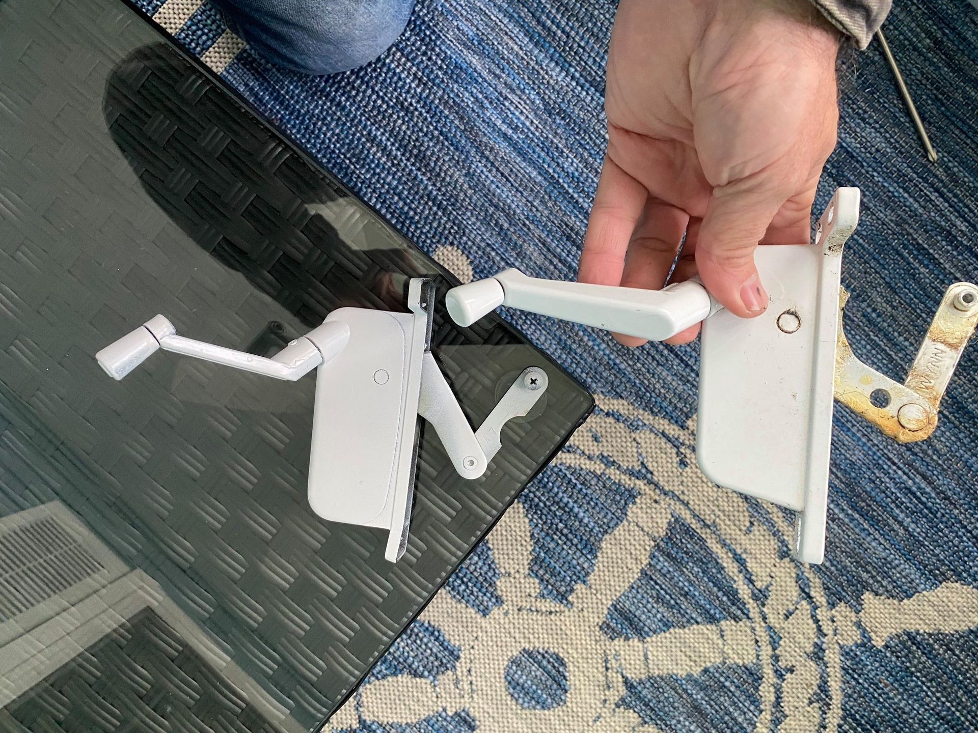 A hand is holding a piece of white plastic on a table