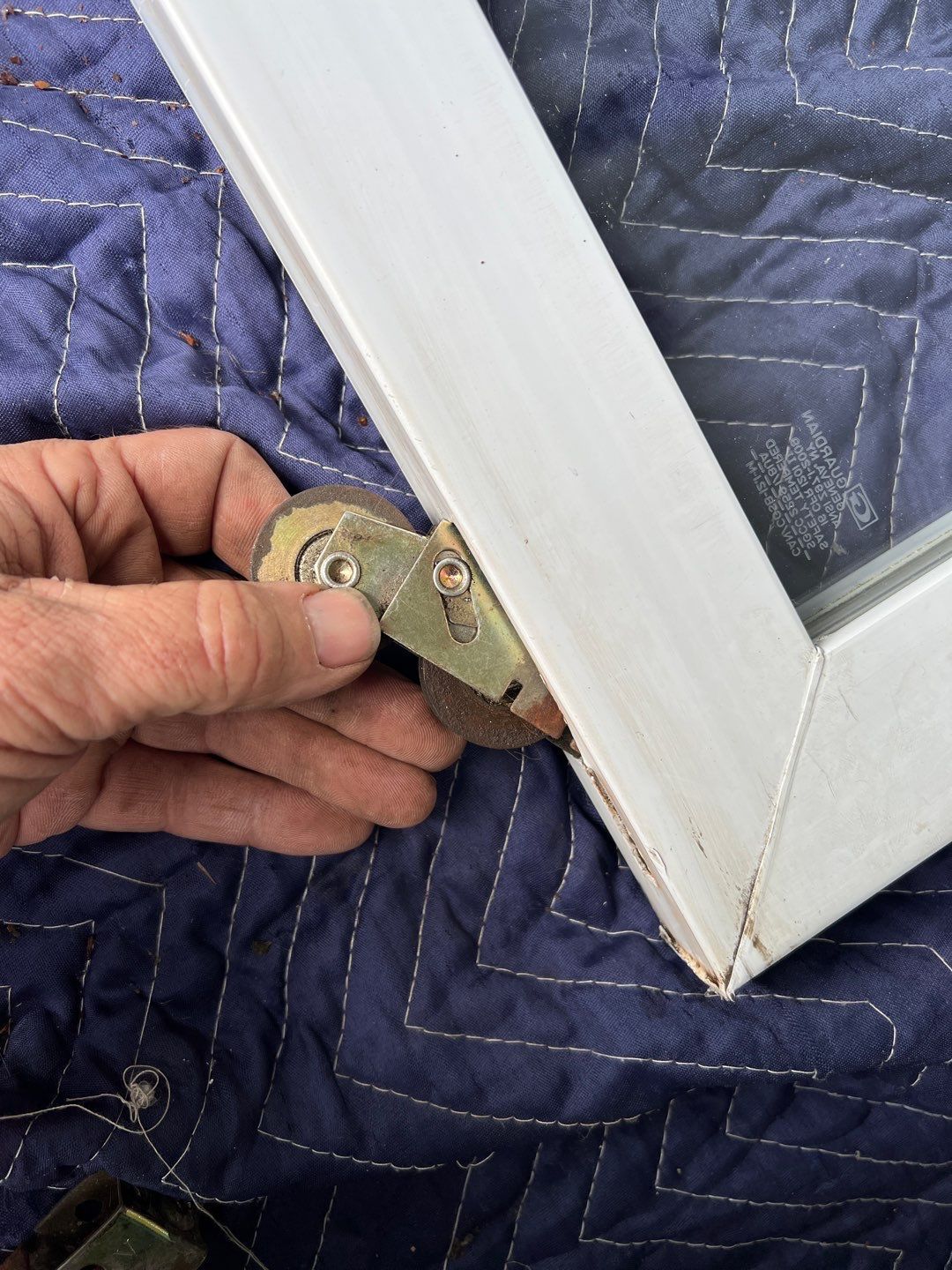 A person is holding a piece of metal next to a window.