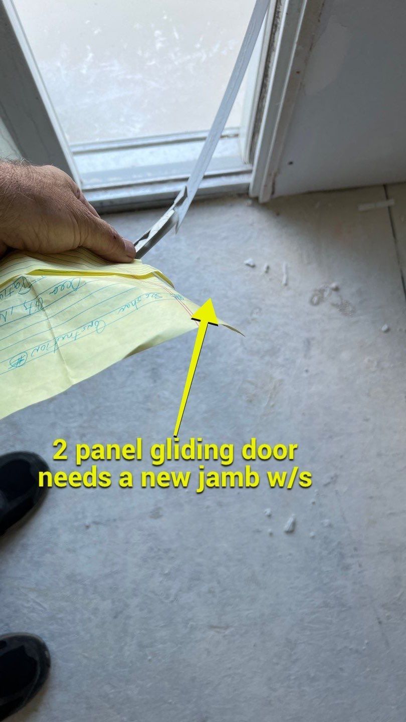 A person is holding a piece of paper in front of a sliding door.