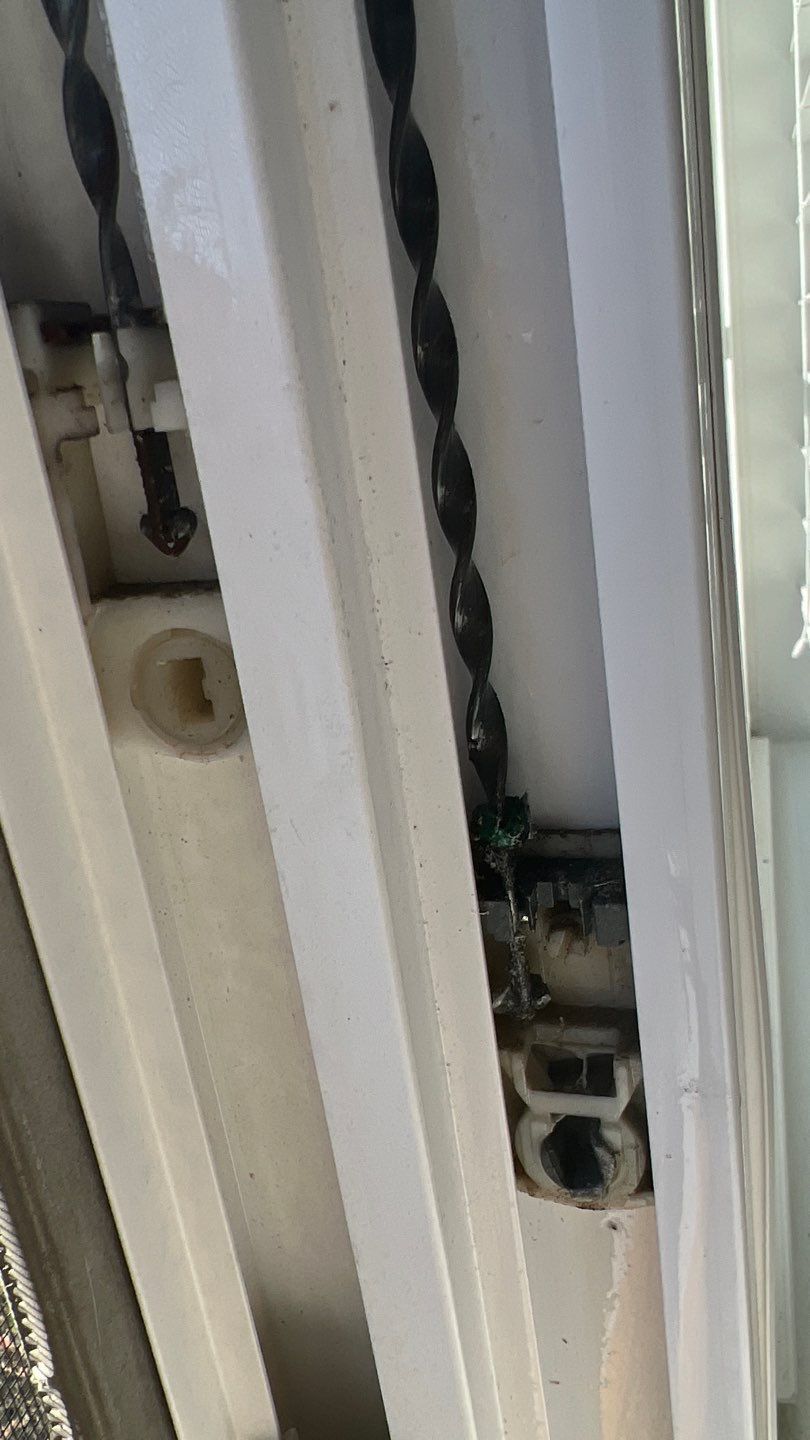 A close up of a sliding glass door with a chain hanging from it.