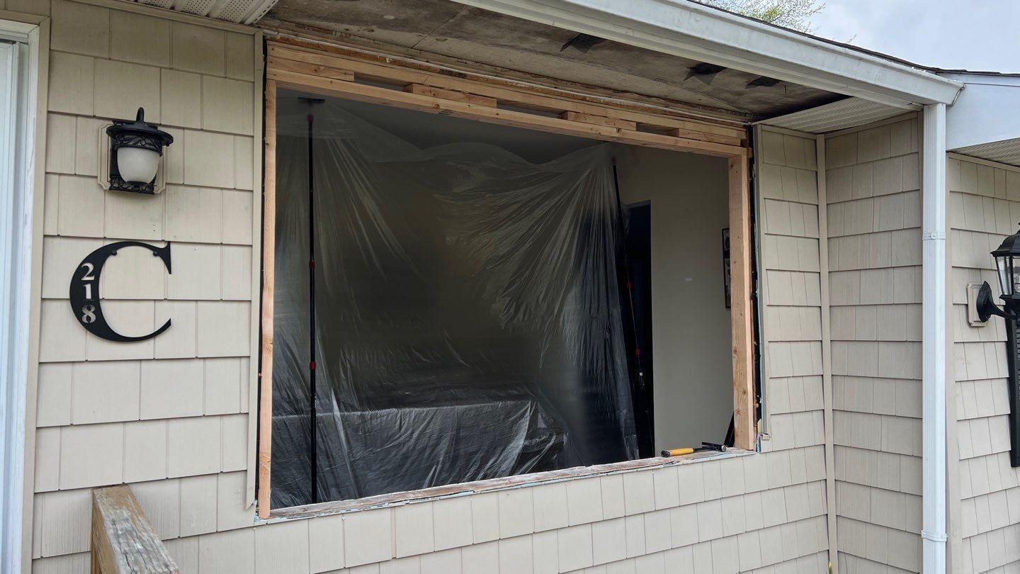 A house with a window being installed on the side of it.