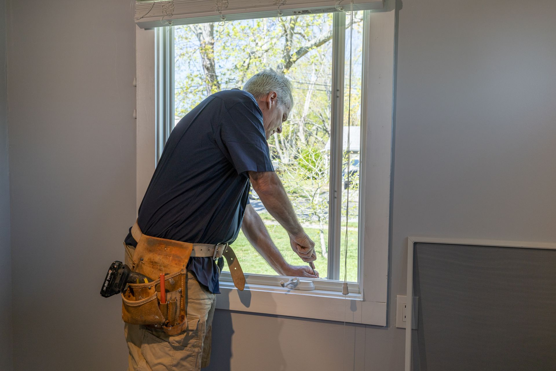 A man is installing a window in a house.