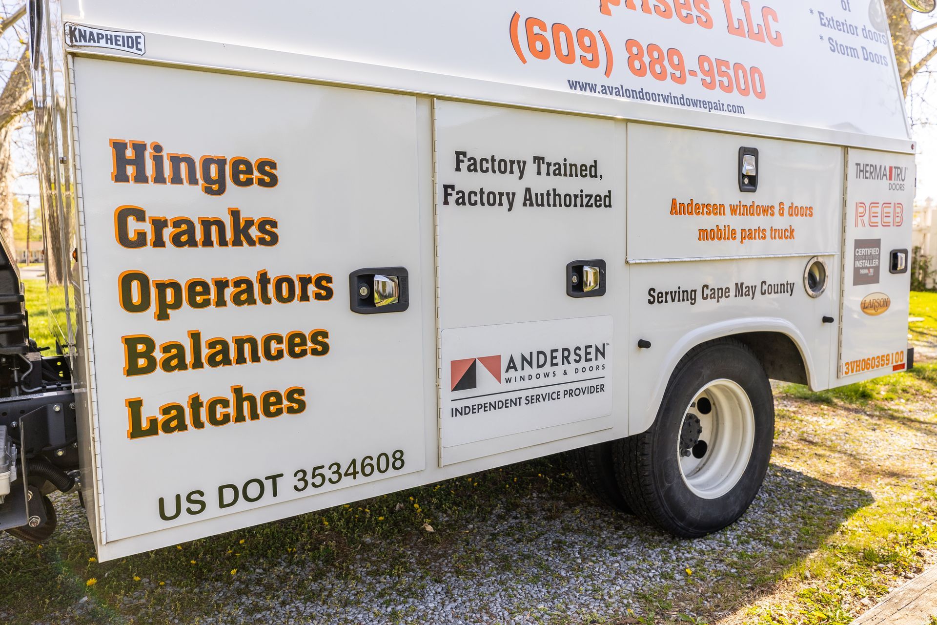 A white trailer with the words hinges cranks operators balances latches on it