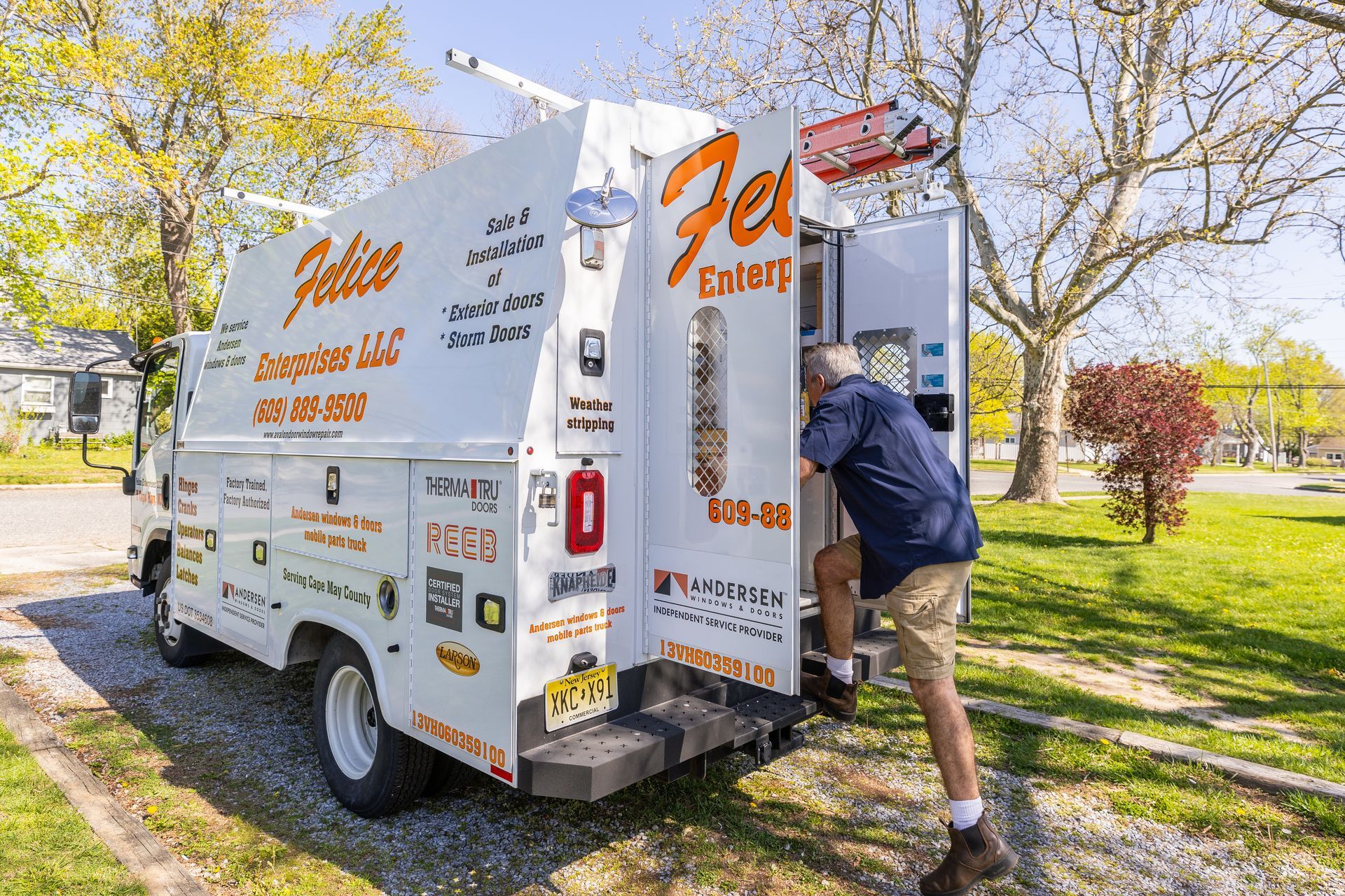 A man is loading a box into the back of a white van.