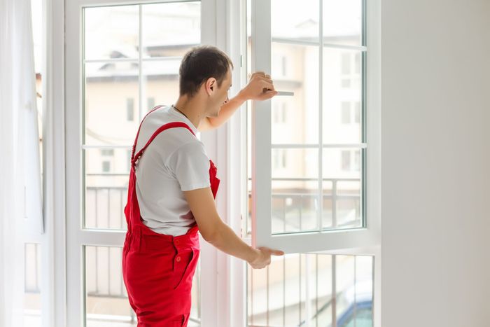 Worker installing new window in house