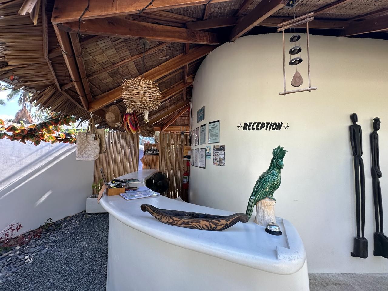 A white reception desk with a parrot on top of it.
