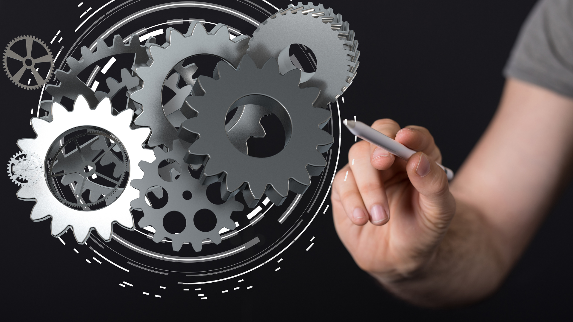 A person is drawing gears on a blackboard with a pen.