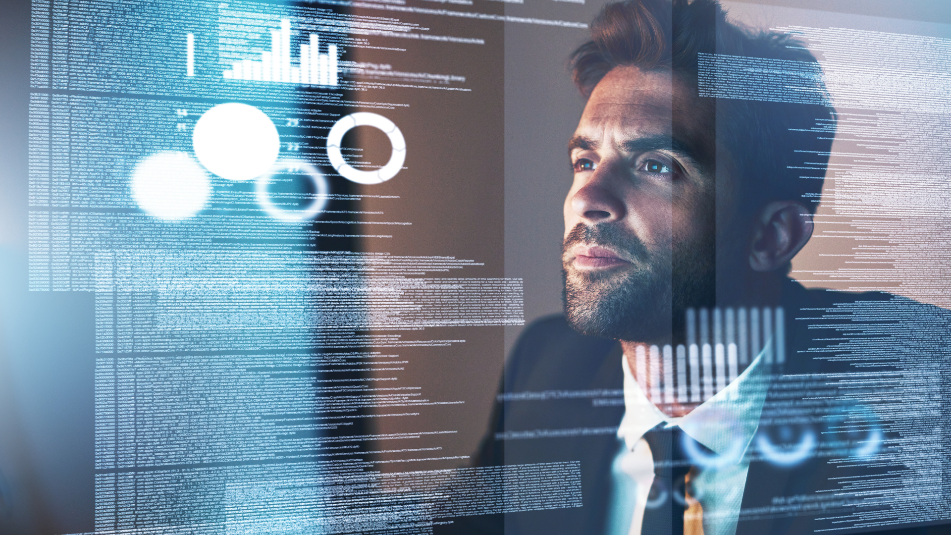 A man in a suit and tie is looking at a computer screen.