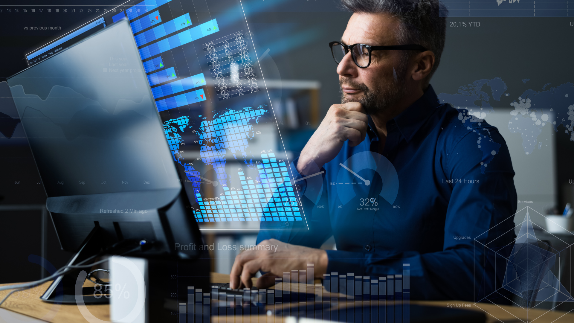 A man is sitting at a desk in front of a computer.