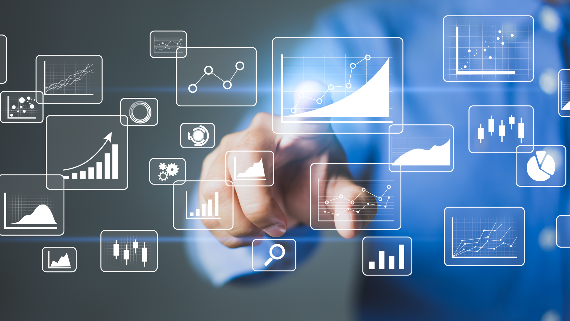 A man is pointing at a screen with graphs and charts on it.