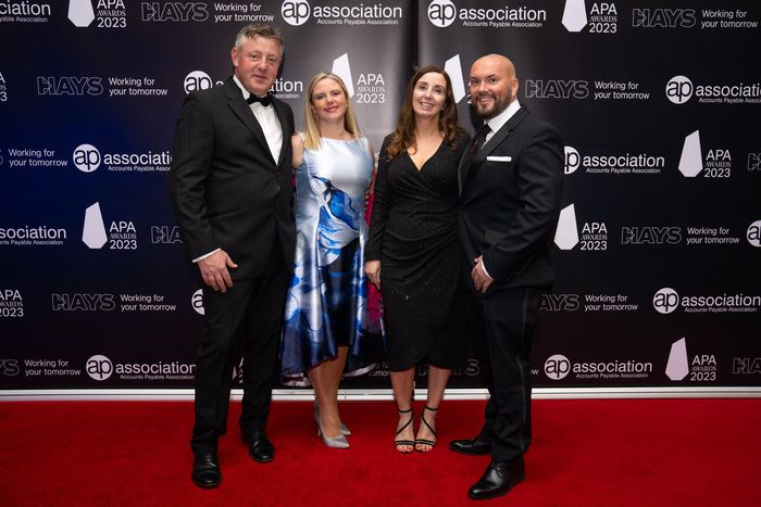 A group of people are posing for a picture on a red carpet.