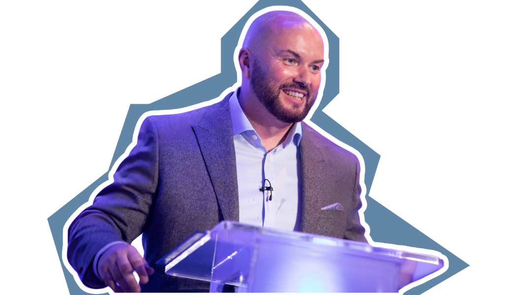 A man in a suit is standing at a podium giving a speech.