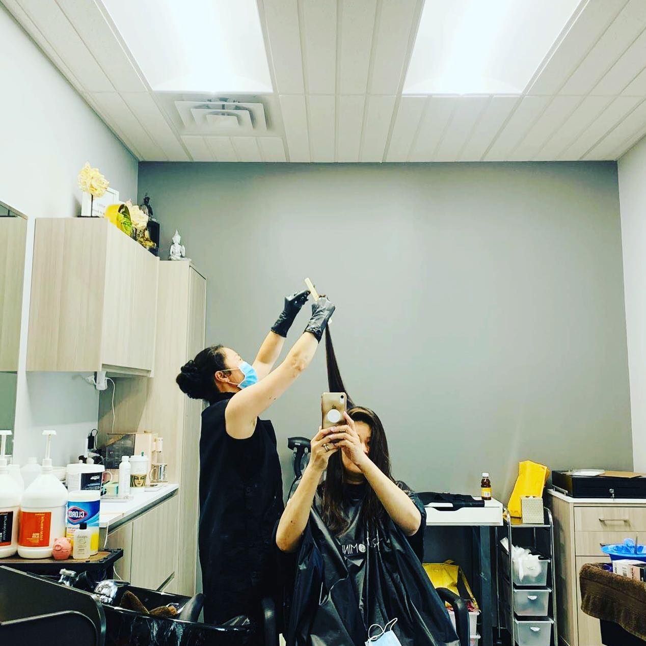 A woman is getting her hair dyed in a salon