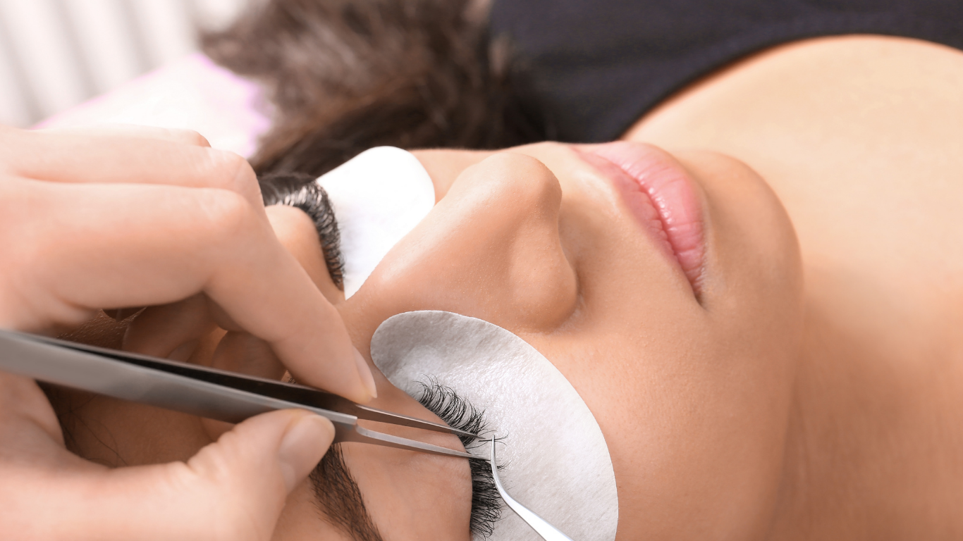 A woman is getting her eyelashes done at a beauty salon.